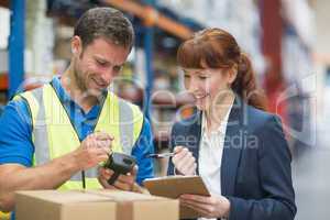 Worker and manager scanning package in warehouse