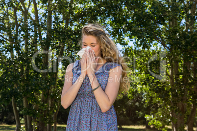 Pretty blonde blowing a her nose