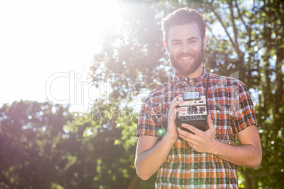 Handsome hipster holding vintage camera