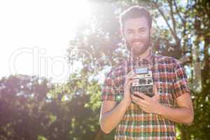 Handsome hipster holding vintage camera