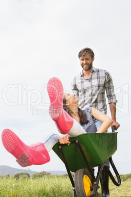 Man pushing his girlfriend in a wheelbarrow