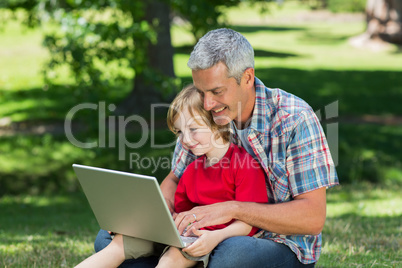 Happy father using laptop with his son