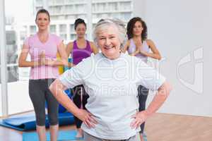 Senior woman with hands on hip standing in gym