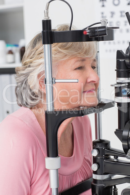 Senior patient looking into slit lamp