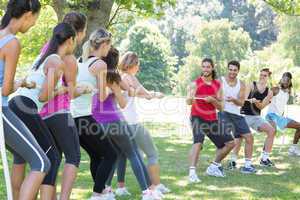 Fitness group playing tug of war