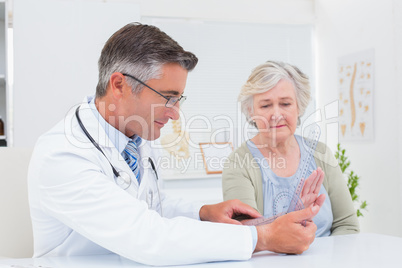 Physiotherapist examining womans wrist with goniometer