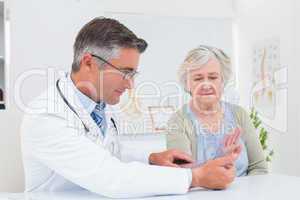 Physiotherapist examining womans wrist with goniometer