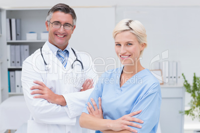 Nurse and doctor standing arms crossed at clinic