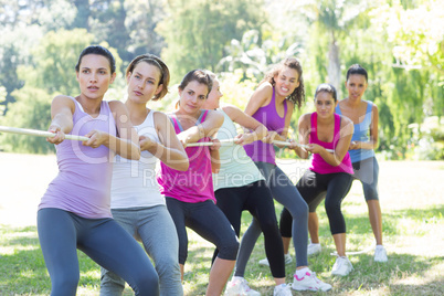 Fitness group playing tug of war