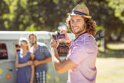 Hipster taking a photo of his friends Hipster taking a photo of his friends