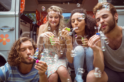 Hipsters blowing bubbles in camper van