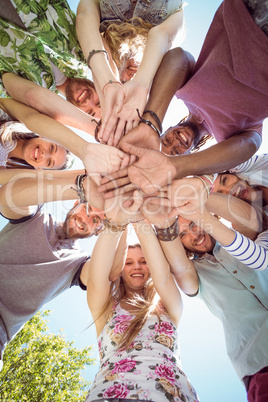 Happy young friends putting hands together