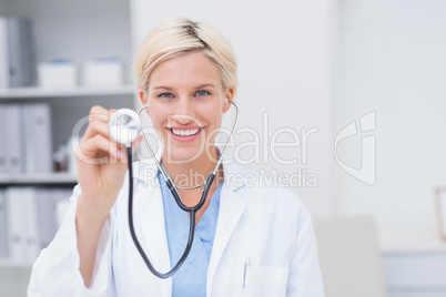 Happy female doctor holding stethoscope
