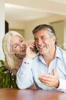 Happy mature couple using smartphone together