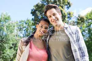 Happy couple smiling at camera in park