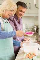 Happy blonde preparing dough with husband