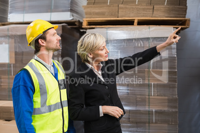 Warehouse manager pointing something to his colleagues