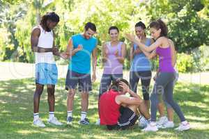 Fitness group encouraging man doing sit ups