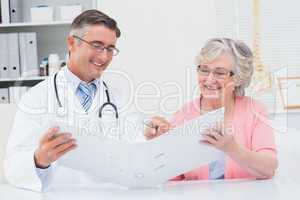 Doctor and female patient looking at reports in file