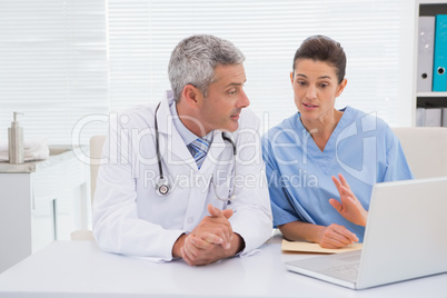 Doctors looking at laptop