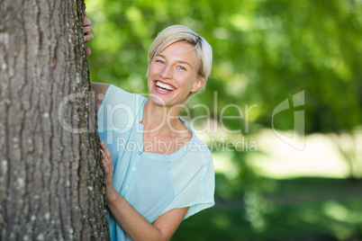 Pretty blonde hidden behind a tree