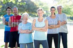 Happy athletic group smiling at camera with hands crossed