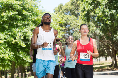 Happy people running race in park