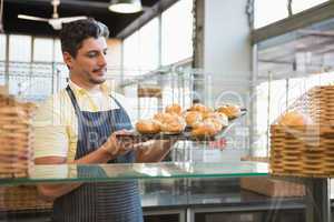 Cheerful waiter holding tray of breads