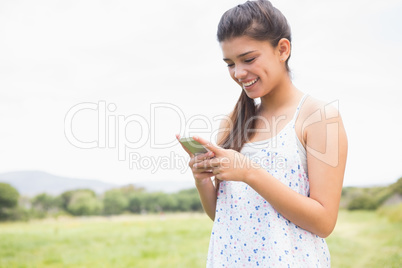 Pretty brunette texting in the park