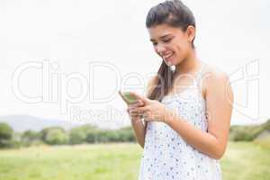 Pretty brunette texting in the park