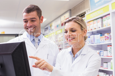 Team of pharmacists looking at computer