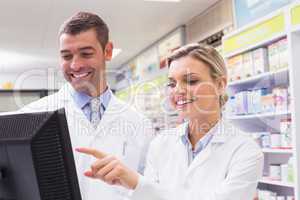 Team of pharmacists looking at computer