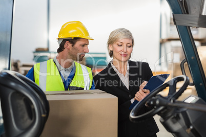 Warehouse manager talking with forklift driver