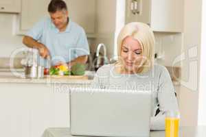 Happy mature blonde using laptop