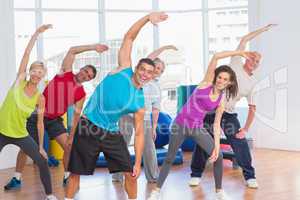 People doing stretching exercise in gym
