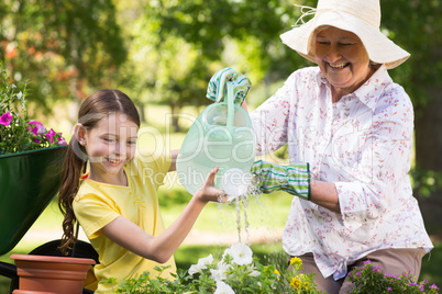 Happy grandmother with her granddaughter gardening