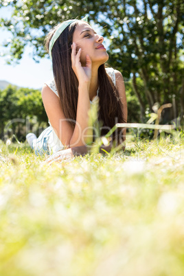 Pretty brunette lying on the grass