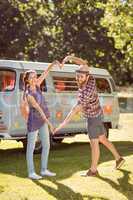 Hipster couple making heart with arms