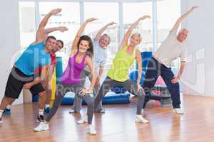 Fit people doing stretching exercise in gym