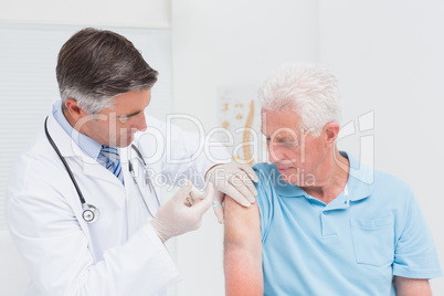 Doctor injecting senior patient in clinic