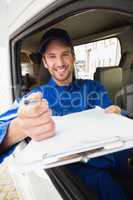 Happy delivery man showing clipboard to sign to customer