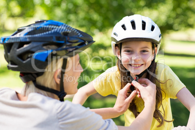 Mother attaching her daughters cycling helmet