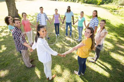 Happy friends in the park holding hands