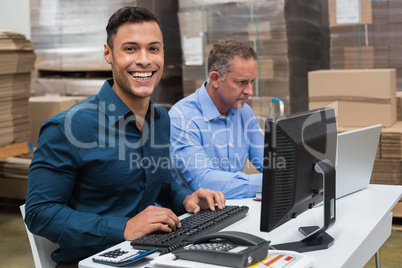 Two managers working on laptop at desk