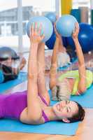 Woman exercising with medicine ball in fitness club