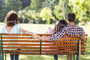 Lonely woman sitting with couple in park