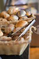 Basket with fresh bread and tongs