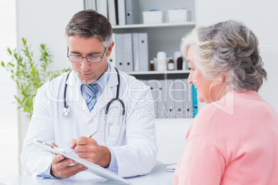 Doctor explaining prescriptions to senior woman