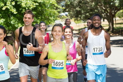 Happy people running race in park