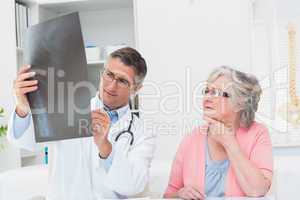 Doctor explaining x-ray to female patient